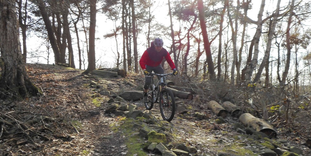 Een mountainbiker rijdt over een rock garden in Papendal