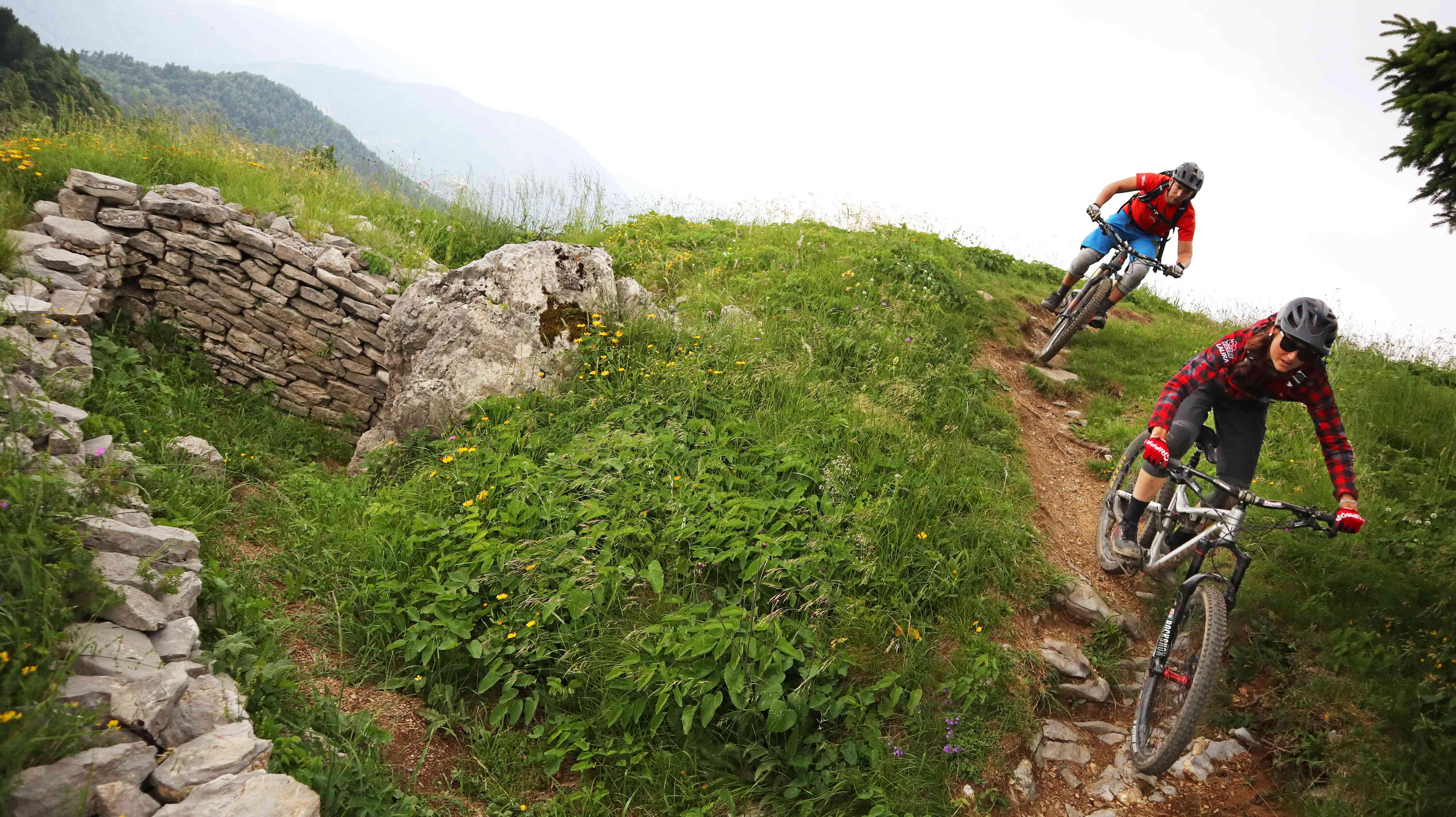 A trail with 2 riders near an old wall in slovenia