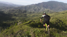 A mountainbiker is riding on his meta v4 over some awesome trails with epic views