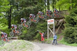 Downhill mountainbiker is jumping the big road gap in Bikepark Winterberg