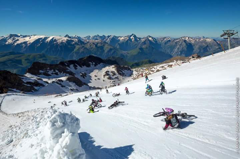 Overliggen en glijden mountainbikers over de besneewde piste tijdens de megavalanche
