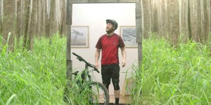 een mountainbiker staat met zijn nieuwe ION kleding verbaast een bos in te kijken