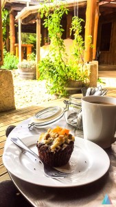 een gebakje ligt op een schoteltje naast een bak verse koffie