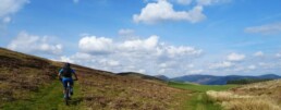 Rik klimt omhoog door een weids landschap in Schotland