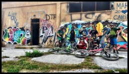 De trailhunters staan met hun alle voor een mooie muur vol met graffiti