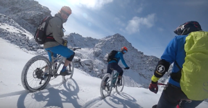 Drie mountainbikers wachten op hun bikes in de verse sneeuw