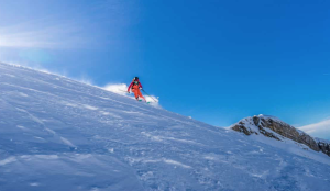 skier op een piste met mooie blauwe hemel